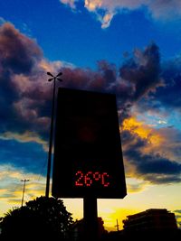 Low angle view of road sign against cloudy sky