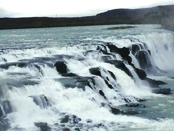 Scenic view of waves flowing through rocks