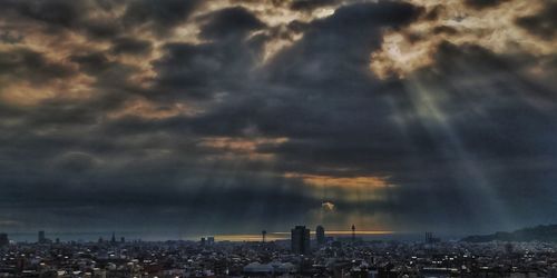 Aerial view of city against cloudy sky