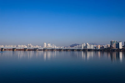 City by sea against clear blue sky