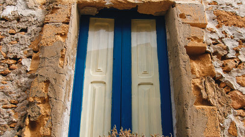 Rustic wall of house and blue painted window of sicily city