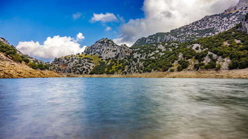 Scenic view of sea and mountains against sky