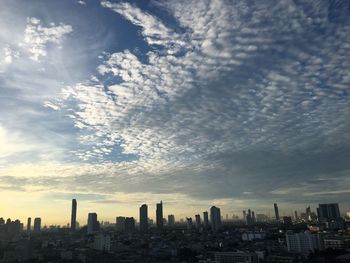 Buildings in city against cloudy sky