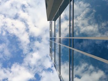 Low angle view of modern building against sky and clouds