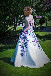 Girl in gown standing on field against tree