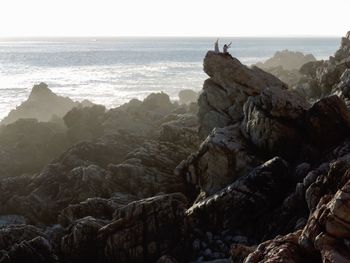 Scenic view of sea against rocky mountains