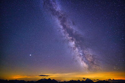 Low angle view of mountain against sky at night and milkyway