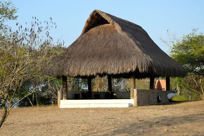 Built structure by trees against clear sky