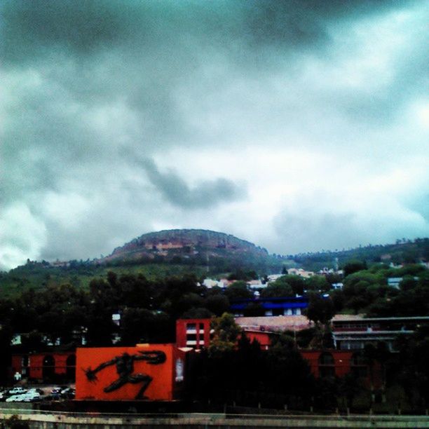 building exterior, sky, mountain, architecture, built structure, cloud - sky, cloudy, tree, house, residential structure, cloud, residential building, town, weather, overcast, residential district, landscape, mountain range, nature, outdoors