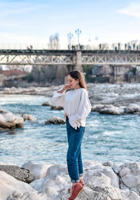 Woman standing on rock by sea