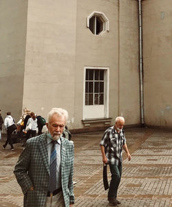 People walking on street against building