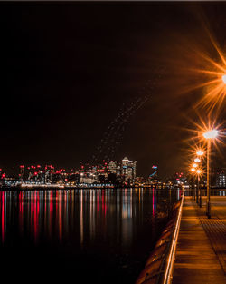 Illuminated cityscape against clear sky at night