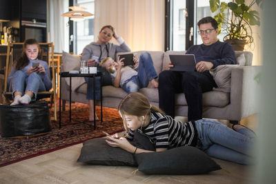 Family is using technologies in living room at modern home