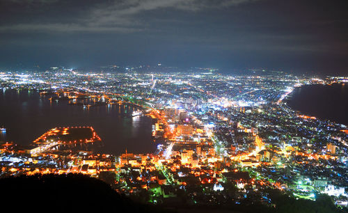 High angle view of illuminated cityscape against sky at night