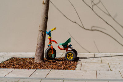 Toy car on footpath by wall