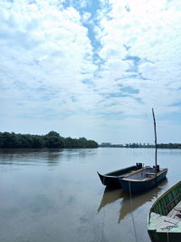 Boat moored in river against sky