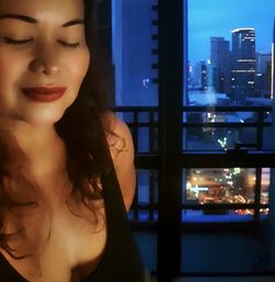 Portrait of beautiful woman in city at night