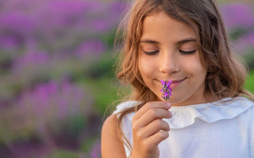 Cute girl smelling flowers at farm
