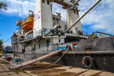 Ship moored on shore against sky