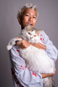 Portrait of cute cat against white background