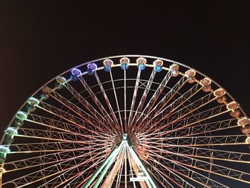 Low angle view of illuminated ferris wheel against sky at night