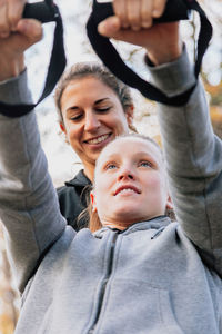 Low angle view of smiling women exercising in park