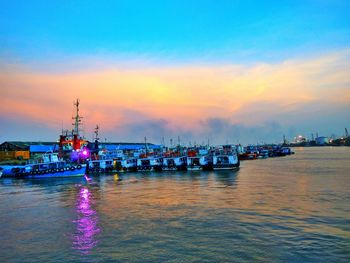 Boats in harbor during sunset