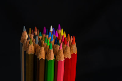 Close-up of multi colored pencils against black background