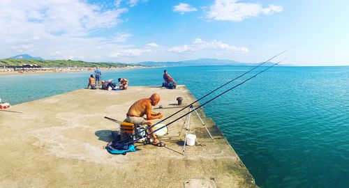 People on sea shore against sky