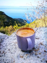 Close-up of coffee on table against mountain
