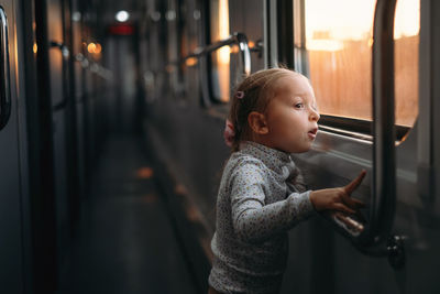 Rear view of boy standing in bus