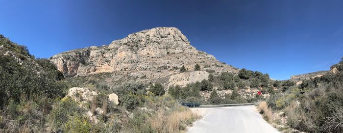 Panoramic view of mountain road against clear blue sky