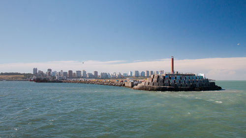 Scenic view of sea by buildings against sky