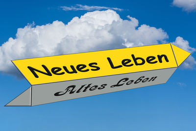 Low angle view of information sign against blue sky