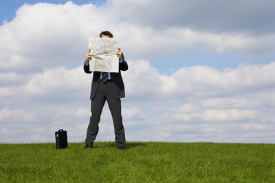 Rear view of man standing on field against sky