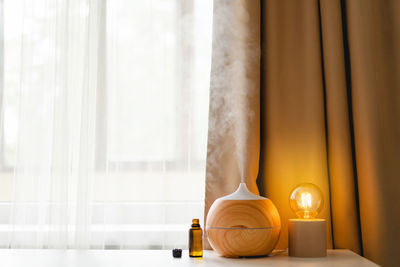 Aromatherapy concept. aroma oil diffuser on the table against the window.