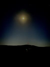 Silhouette landscape against sky at night