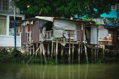 Houses by river against buildings