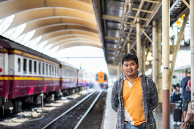 Portrait of man standing at railroad station platform