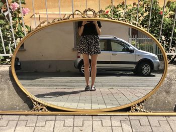 Woman legs standing on road, reflection, vintage mirror selfie