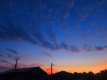 Silhouette electricity pylon against sky during sunset