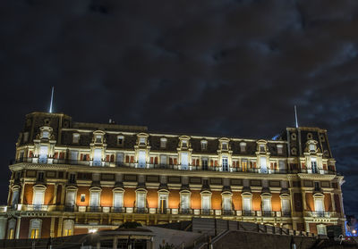 Low angle view of illuminated building against sky at night