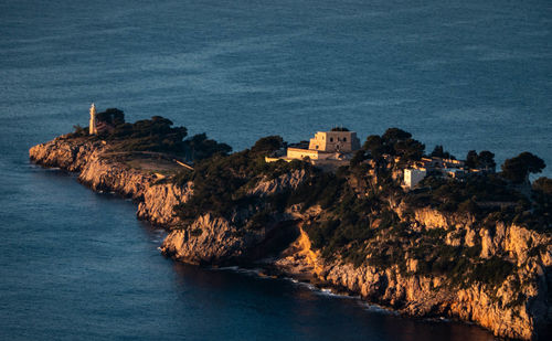 Buildings by sea against sky