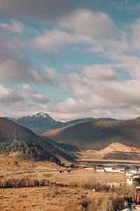 Scenic view of field and mountains against sky