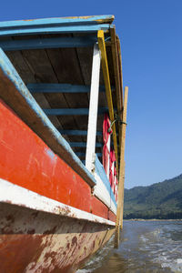 Close-up of a wooden river boat on the river mekong in south-east asia. slow travel and tourism.