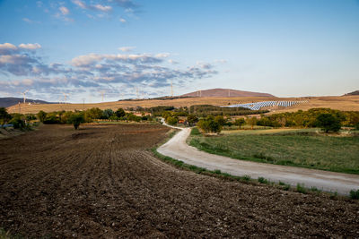 Road by landscape against sky
