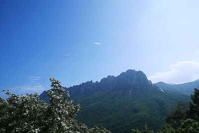 Scenic view of mountains against blue sky