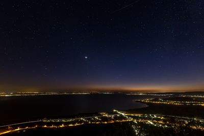 Illuminated city against sky at night