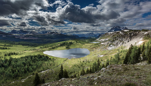 Scenic view of lake by mountains against sky