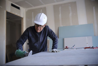 Concentrated worker with power tool at construction site